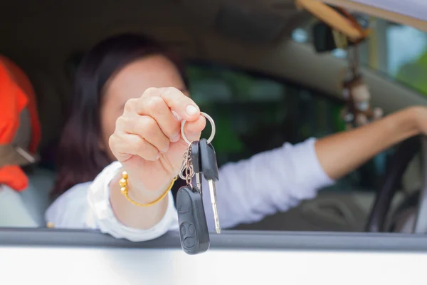 Hand of woman holding a car key. Selective focus. Car sale & rental business concept.