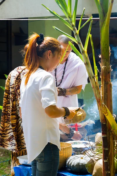 CHIANG RAI, THAILAND - SEPTEMBER 1 : unidentified hermit in tiger-skin cloth and a woman ritualising in front of altar table on September 1, 2016 in Chiang rai, Thailand.