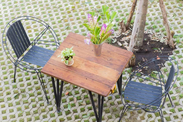 Horizontal photo of Top view of table and two chairs with hole pattern floor.