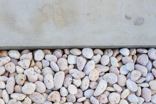 White pebble stones with gray concrete ground