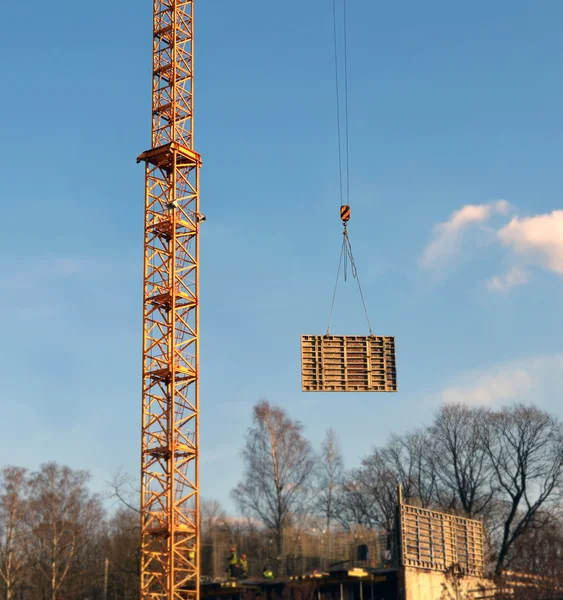 Fragment of a tower of a lifting tower crane and the moved freig