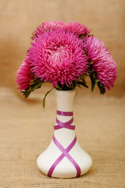 Autumn bouquet of flowers in a white vase. Autumn colors maroon red.