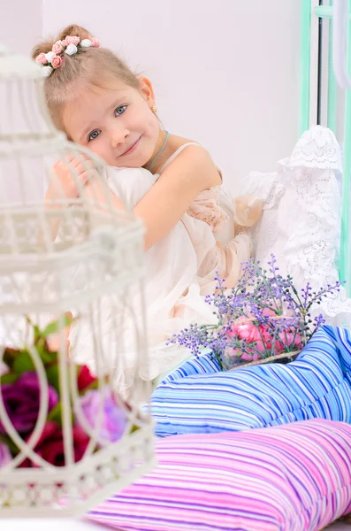 Little girl with birdcage in home interior