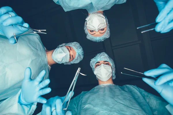 Medical team hospital performing operation. Group of surgeon at work in operating theatre room. healthcare . - Stock Image - Everypixel Medical team hospital performing operation. Group of surgeon at work in operating theatre room. healthcare . - Stock Image - Everypixel