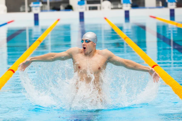 Dynamic and fit swimmer in cap breathing performing jumping out the water, concept of victory, freedom, happiness, healthy lifestyle