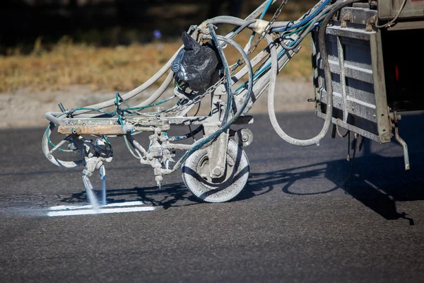 Teamwork: Pavement Asphalt Road Marking Paint and Striping with Thermoplastic Spray Applicator Machine during highway construction works