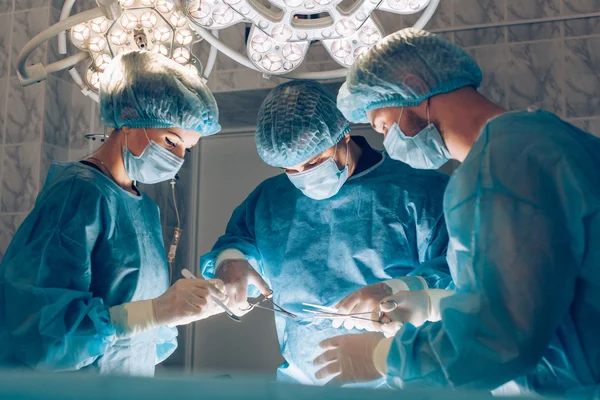 Surgeons team working with Monitoring of patient in surgical operating room. breast augmentation
