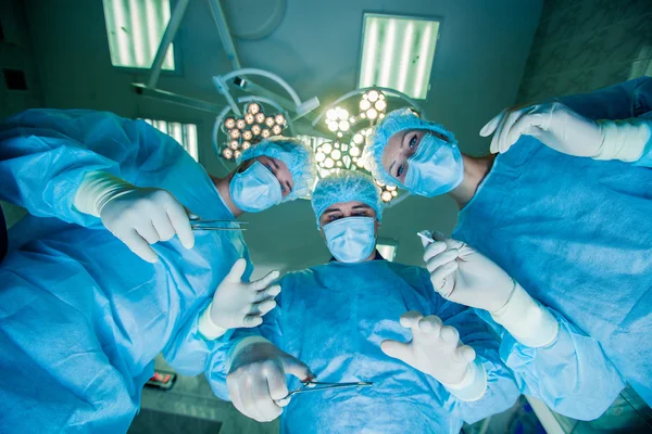 Surgeons standing above of the patient before surgery