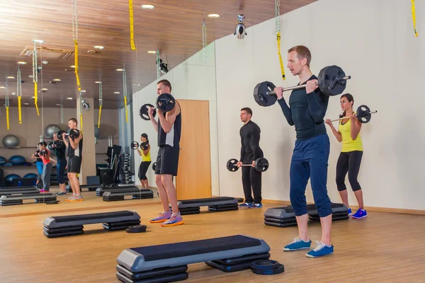 Sport, fitness, lifestyle and people concept - group flexing muscles with barbells in gym