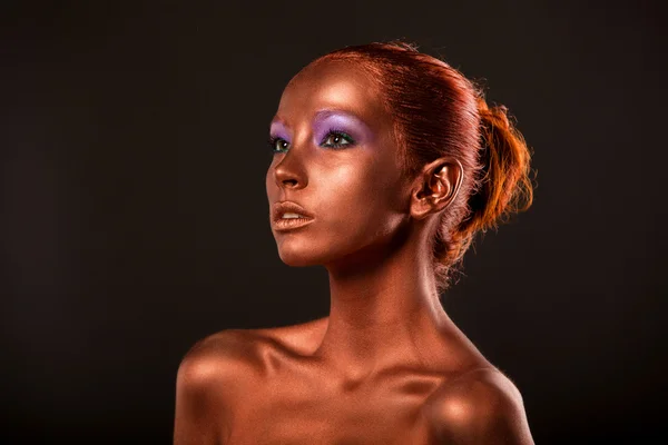 Gilt. Golden Womans Face Closeup. Futuristic Gilded Make-up. Painted Skin bronze.