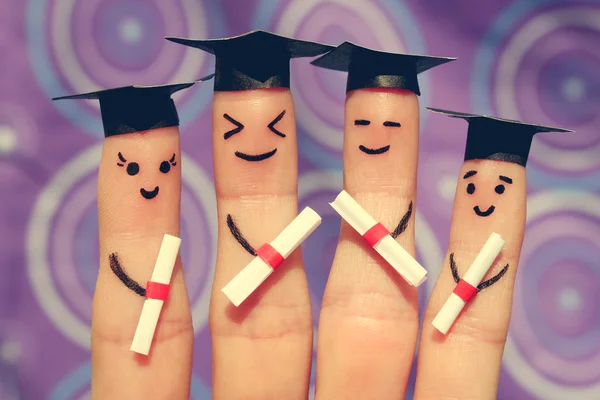 Finger art of students. Graduates holding their diploma after graduation. Toned image