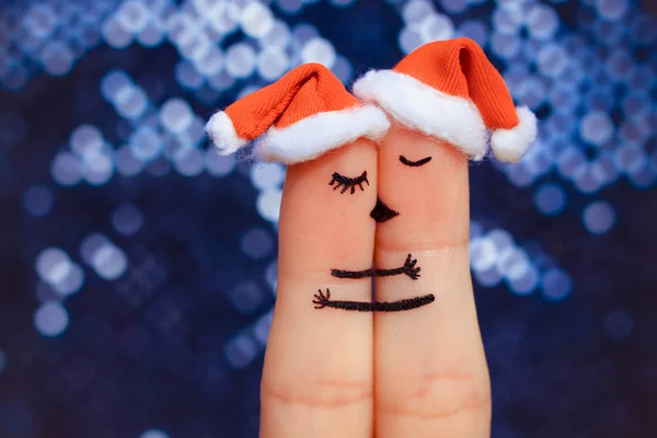 Finger art of a Happy couple. Couple kissing and hugging in the new year hats.