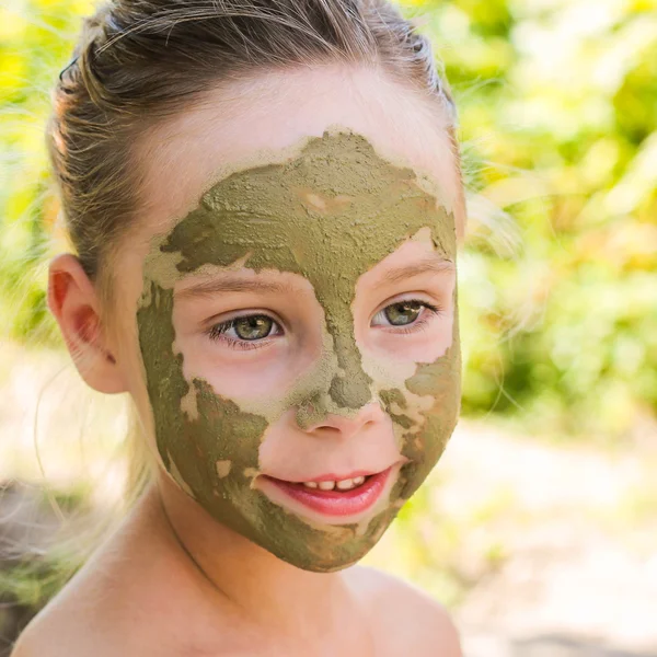 Close up of beautiful girl with facial clay mask