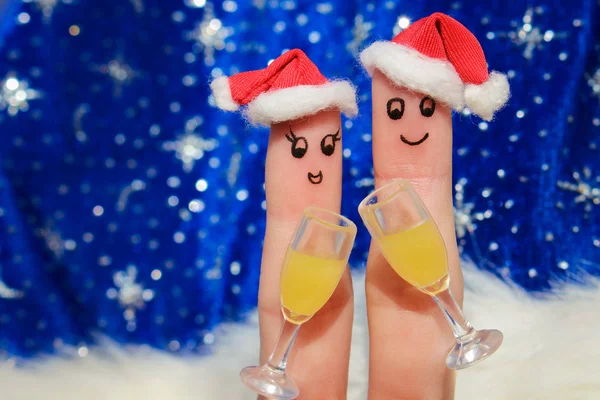 Finger art of a Happy couple. Couple making good cheer  in the new year hats. Two glasses of champagne.