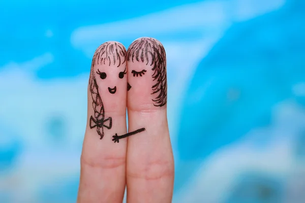Finger art of two women. woman is kissing his girlfriend on the cheek.
