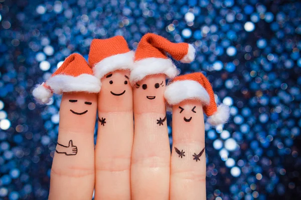 Finger art of friends celebrates Christmas. The concept of a group of people laughing in new year hats.