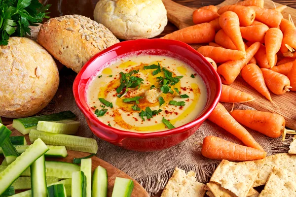 Classic Homemade hummus with olive oil, carrots, cucumber, flatbread, parsley.