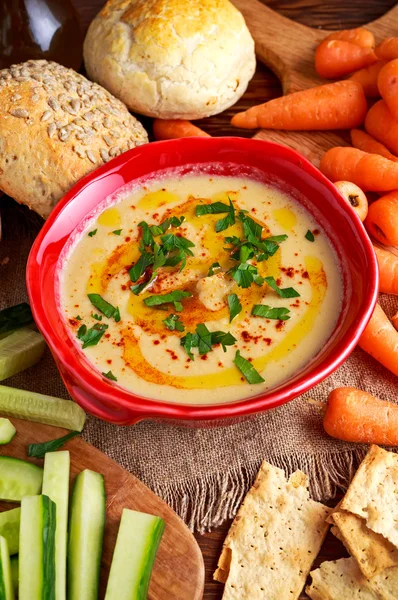 Classic Homemade hummus with olive oil, carrots, cucumber, flatbread, parsley.