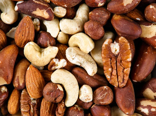 Natural background texture made from mixed kinds of nuts - pecans, hazelnuts, walnuts, cashews, almonds, pine nuts, pistachios