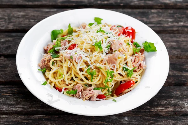 Italian Tuna Pasta spaghetti with tomato, chilli, parmesan and wild rocket  lives. on old wooden table