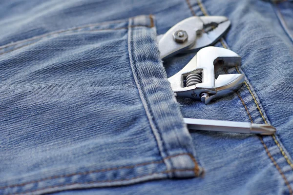 Several tools in workers pocket jeans