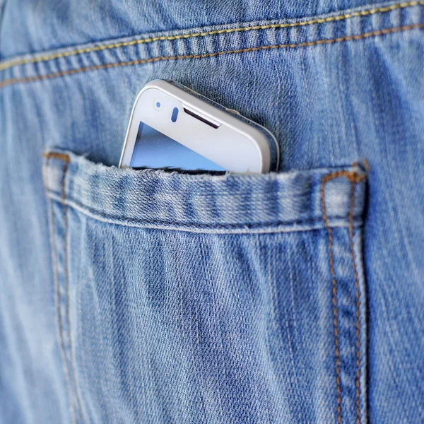 Mobile smart phone in pocket blue jeans
