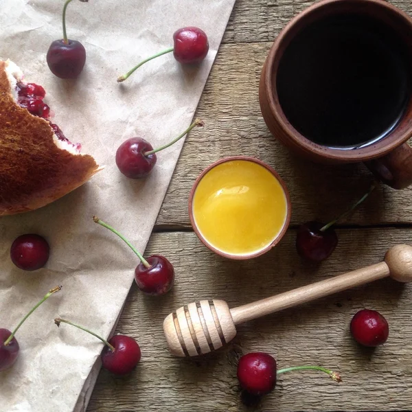 Cup of black coffee, honey and cherries