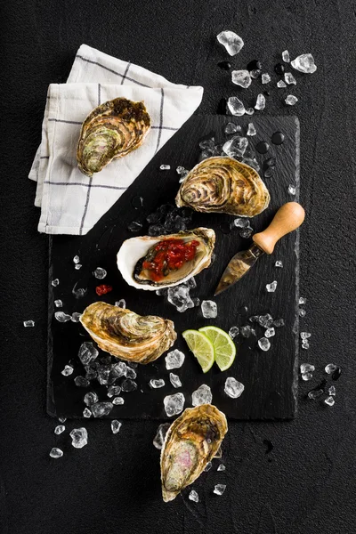 Fresh oysters on a black stone plate top view