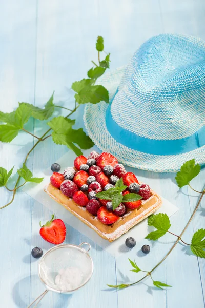 Waffles with strawberry and berry fruit on blue table top view