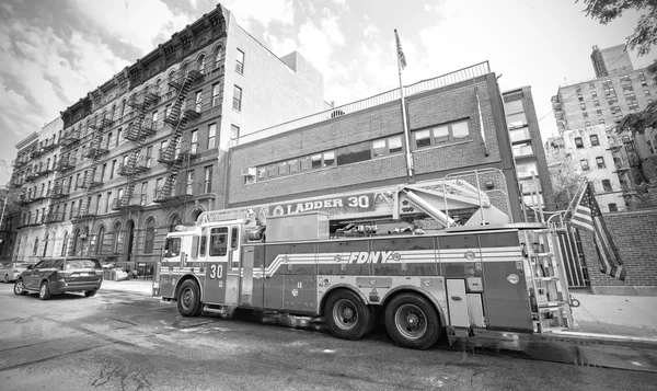FDNY fire truck parked in front of engine house.