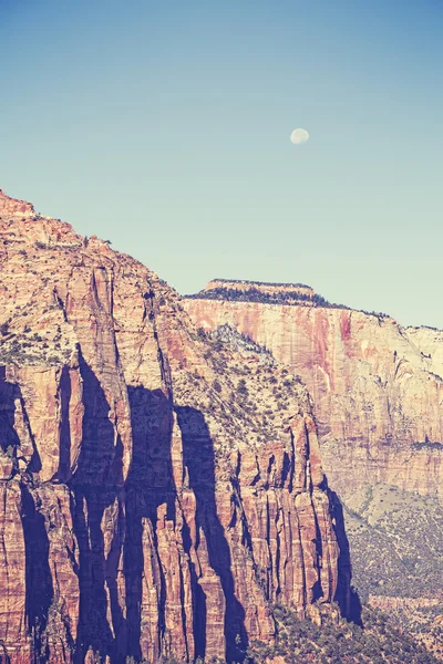 Vintage toned moon over mountains in Zion National Park, USA.