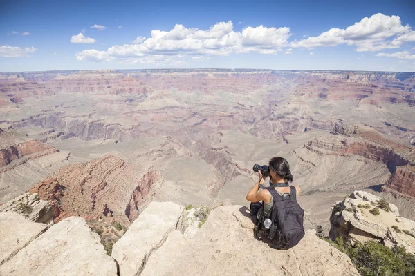 Young woman taking pictures of the Grand Canyon.