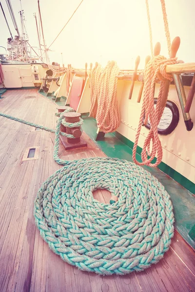 Vintage toned mooring rope on wooden deck.