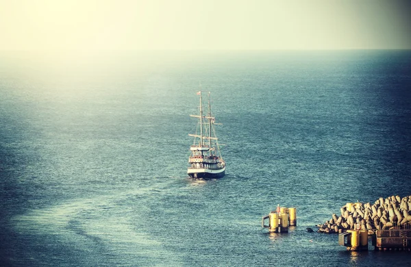 Vintage picture of old sailing ship leaving port.