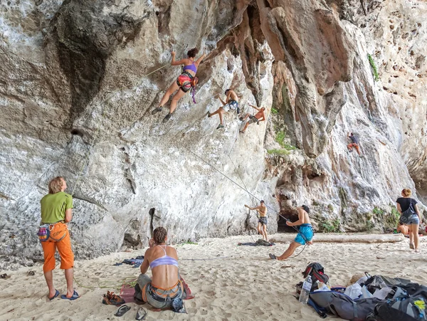 Rock climbers climbing the wall on Railay beach.