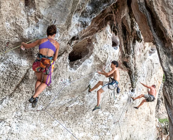 Rock climbers climbing the wall on Railay beach.