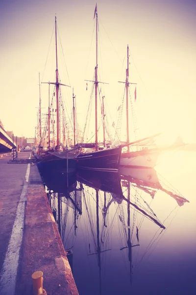 Vintage stylized sailing boats at sunrise.