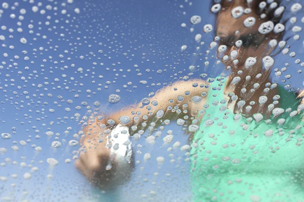 Washing car window, soap bubbles from inside.