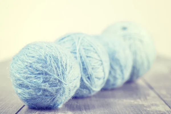 Vintage toned wool balls on a wooden background