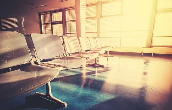 Vintage filtered picture of empty airport waiting room at sunrise
