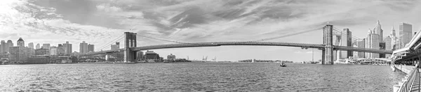 Black and white panoramic picture of Brooklyn Bridge, New York.