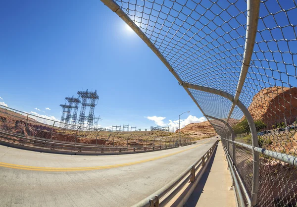 Fisheye lens photo of road and energy infrastructure against sun