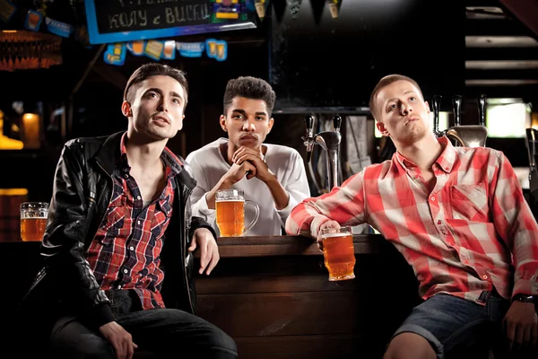 Watching TV in bar. men drinking beer sitting  bar