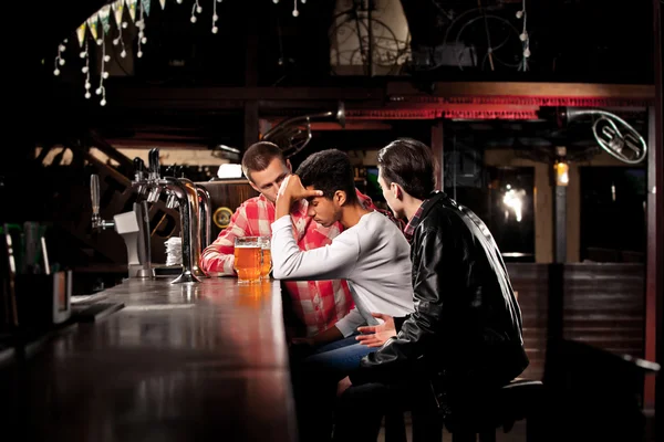 Friends drink beer and spend time together in a bar.