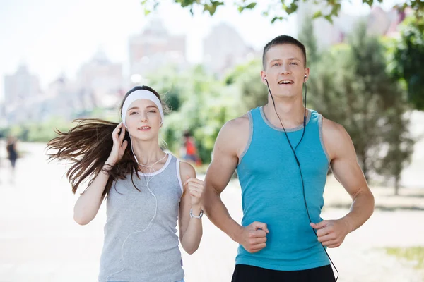 Young couple jogging in park at morning. Health and fitness.