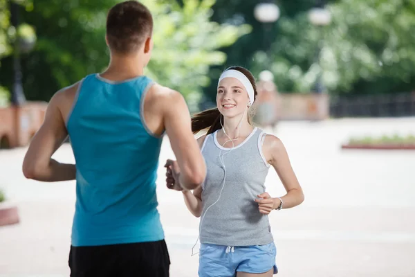 Young couple jogging in park at morning. Health and fitness.