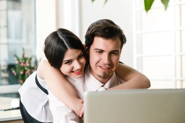Happy young relaxed couple working on laptop computer