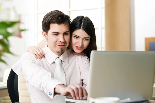 Happy young relaxed couple working on laptop computer