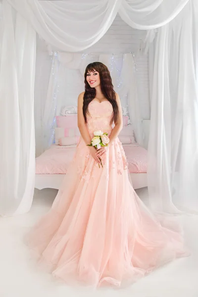 Weddings Christmas and New Year.Beautiful young bride in a peach dress. The gentle light bedroom.Wedding in pink.