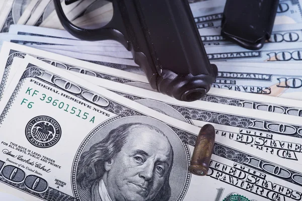 Gun with bullet on US dollar banknotes.
